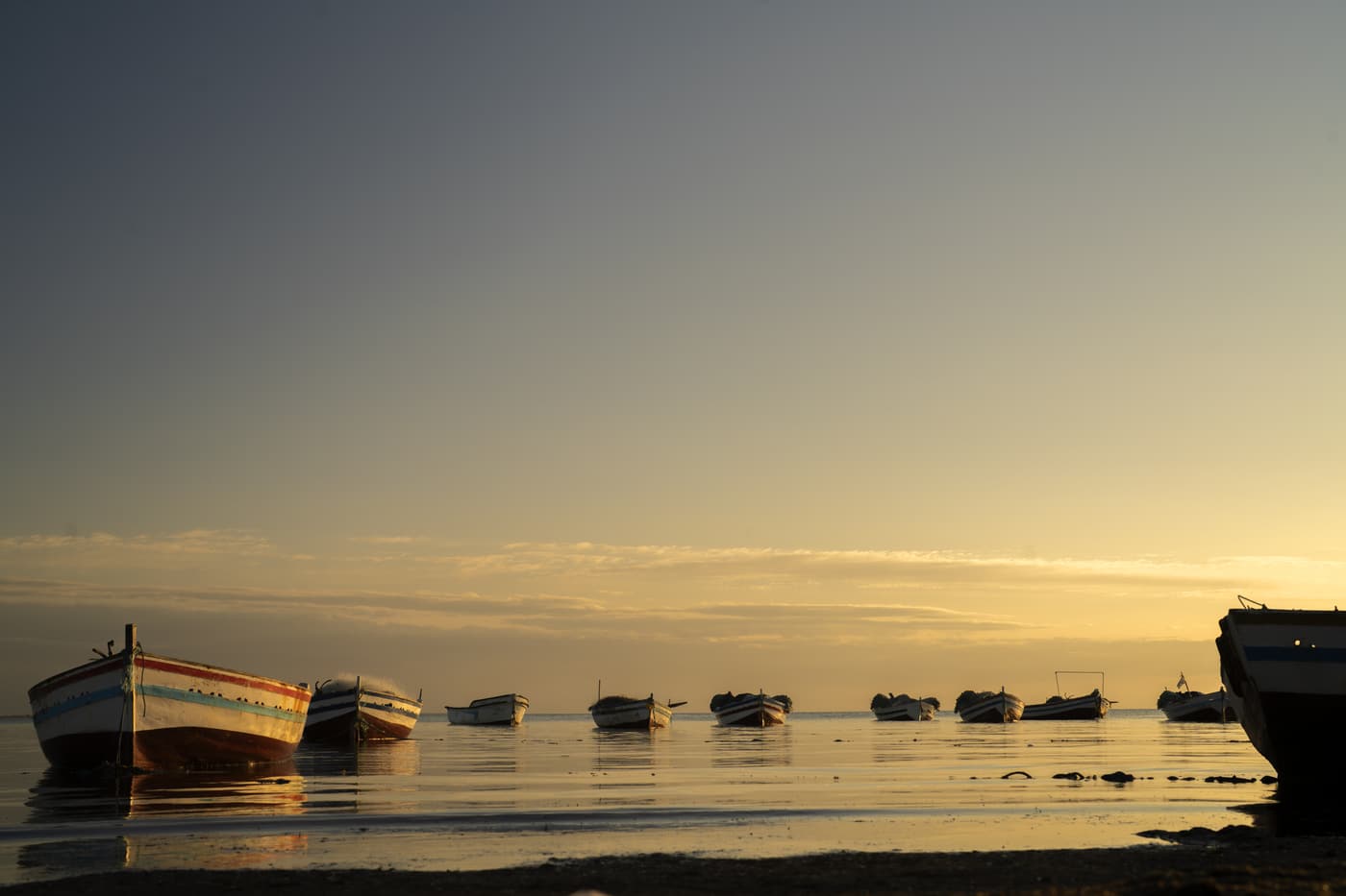Small wooden fishing boats on a calm sea at dusk off Djerba