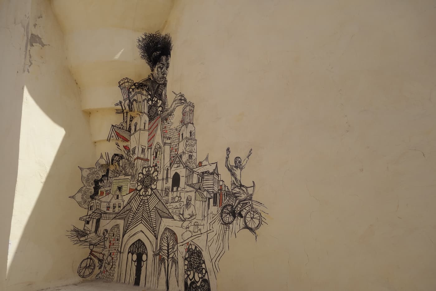 A black-ink mural of a fantastical building on a whitewashed wall in Erriadh